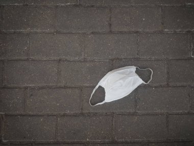 Kapat. Kaldırımda koruyucu maske kullanılmış.