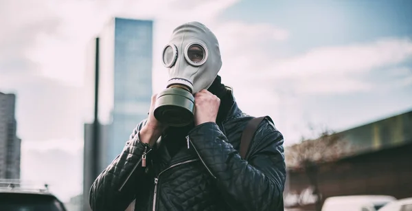 Joven con una máscara de gas en una calle de la ciudad — Foto de Stock