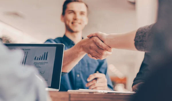 Close up. smiling young man shaking hands with his business partner. — Stock Photo, Image