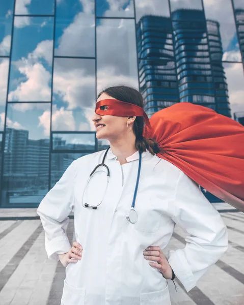 female doctor in a superhero raincoat looks at a city street .