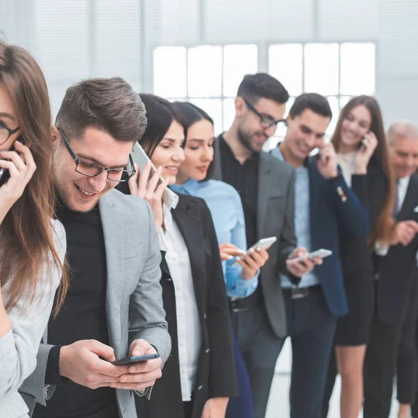 Grupo de jovens diversos usam seus smartphones — Fotografia de Stock