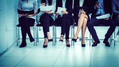 Bir grup iş adamı iş toplantısına başlamadan önce aletlerini kullanırlar.