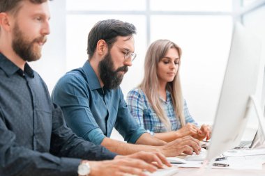 Kapat. Genç çalışanlar kişisel ofis bilgisayarlarında çalışırlar