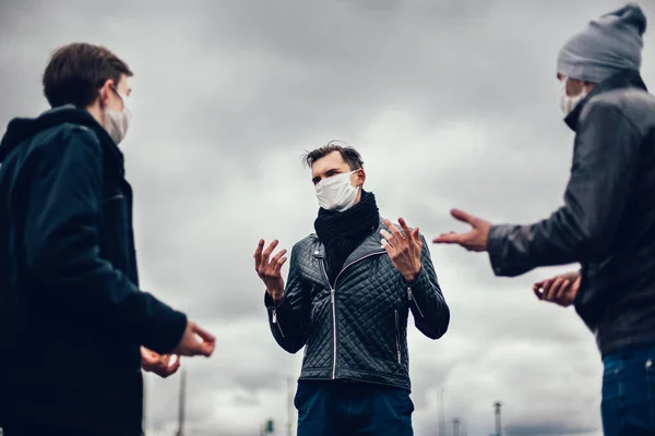 Jongeren met beschermende maskers communiceren op straat — Stockfoto