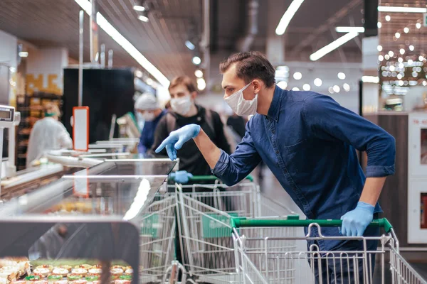 De près. jeune homme choisissant des produits dans un supermarché — Photo