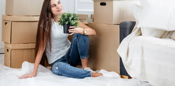 Mujer joven sueña con sentarse en el suelo en un nuevo apartamento — Foto de Stock