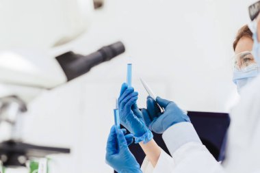 Kapat. Bilim adamının nehirlerinde test sonuçları olan tüpler..
