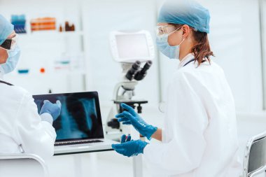 Kapat. Laboratuvarda röntgenleri tartışan doktorlara..