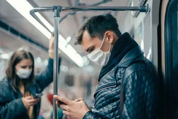 Passageiros em máscaras de proteção de pé no carro do metrô. — Fotografia de Stock