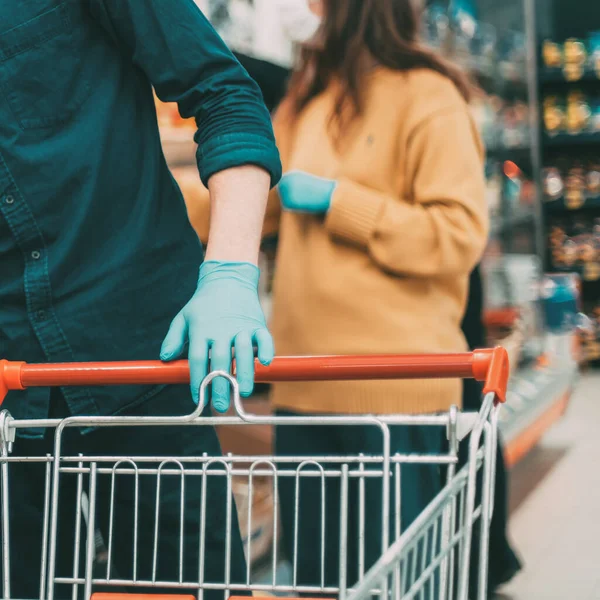 Shoppers in protective masks choosing fruit in the supermarket — Stock Photo, Image