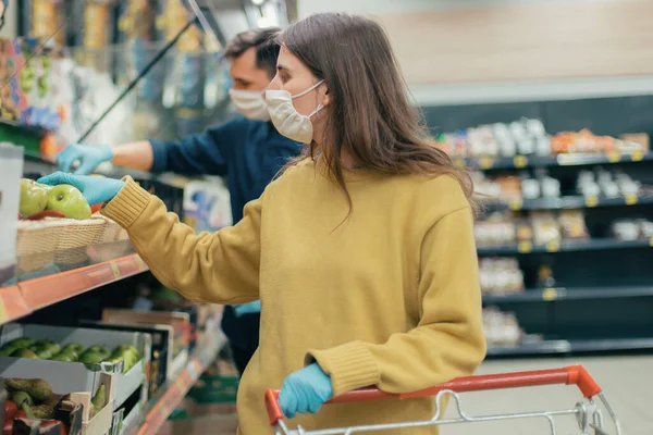 Young woman in a protective mask buys apples — Stock Photo, Image