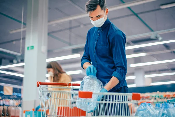 Acheteurs dans des masques de protection en choisissant des produits dans le supermarché. — Photo