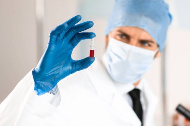 Kapat. Bir bilim adamının elinde aşı olan ampul..