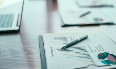 Kapat. Masaüstünde finans şeması ve kalem.