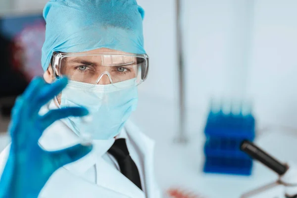 Vicino. scienziato che guarda una capsula con un nuovo vaccino. — Foto Stock