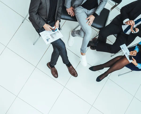 Vista dall'alto. dipendenti che utilizzano il proprio smartphone durante una riunione di lavoro — Foto Stock