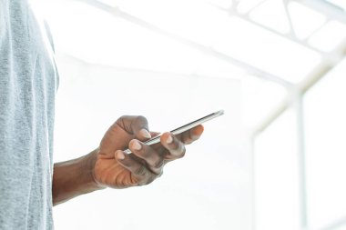 Kapat. Genç adam akıllı telefonunun ekranına bakıyor..