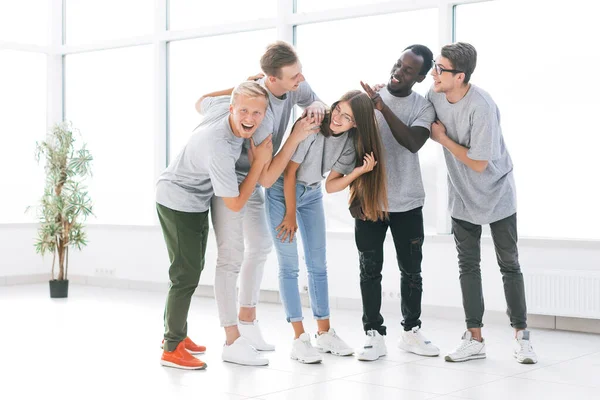 Equipo de jóvenes profesionales de pie en una oficina luminosa — Foto de Stock