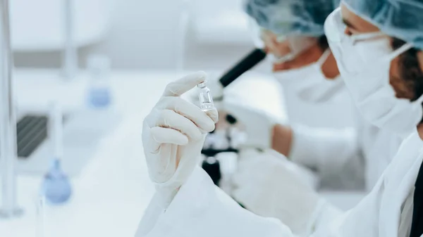 Fecha. ampola com uma nova vacina nas mãos de um cientista. — Fotografia de Stock