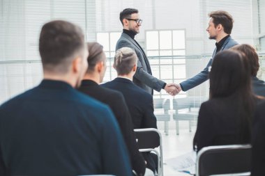 Mutlu meslektaşlar birbirleriyle tokalaşırken.