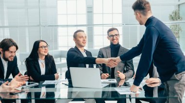 Finansal ortaklar bir ofis toplantısında birbirlerini selamlıyorlar.