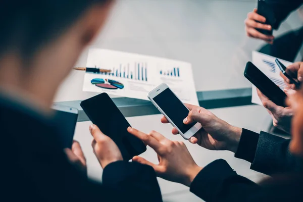 Fecha. funcionários com smartphones analisando dados financeiros. — Fotografia de Stock