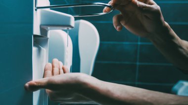 Kapat. Genç adam bakteriyel yıkama kullanıyor.