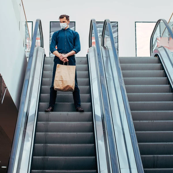 Einsamer Mann mit Schutzmaske steht auf der Rolltreppe — Stockfoto