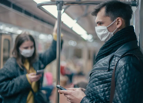 Passageiros em máscaras de proteção de pé no carro do metrô. — Fotografia de Stock