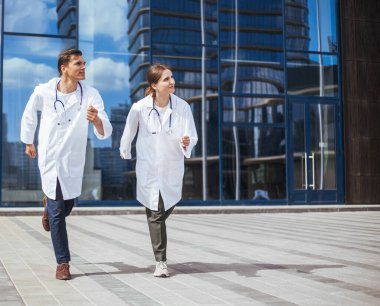 Sağlık görevlileri acil bir çağrı için şehir caddesinde koşuyorlar..