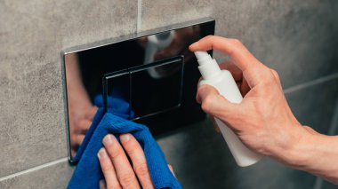 Kapat. Adam duvardaki düğmeye antibakteriyel sprey sıktı..