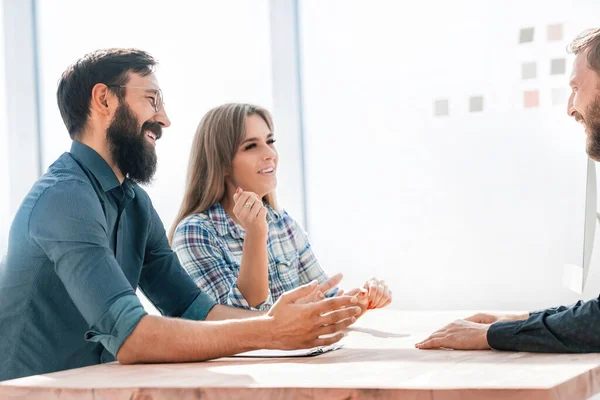 business colleagues discussing current tasks sitting at the Desk.