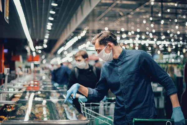 Client en gants de protection regardant les produits dans le réfrigérateur — Photo