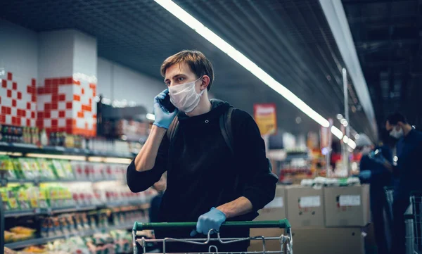 De près. jeune homme dans un masque de protection parlant sur son smartphone. — Photo