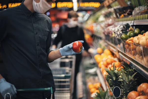 Pomme fraîche dans les mains d'un homme en gants de protection — Photo