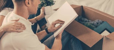 Genç bir çift yeni bir dairede yerde oturuyor..