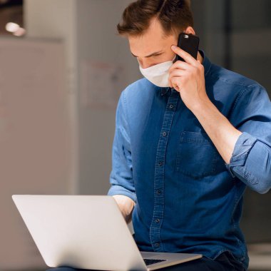 Kapat. Şehir binasının yakınında cep telefonuyla konuşan bir adam..