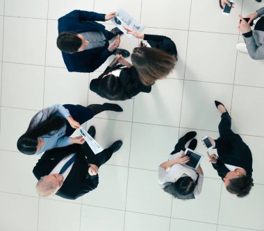 Üst Manzara. Toplantıdan önce finansal verileri tartışan çalışanlar.