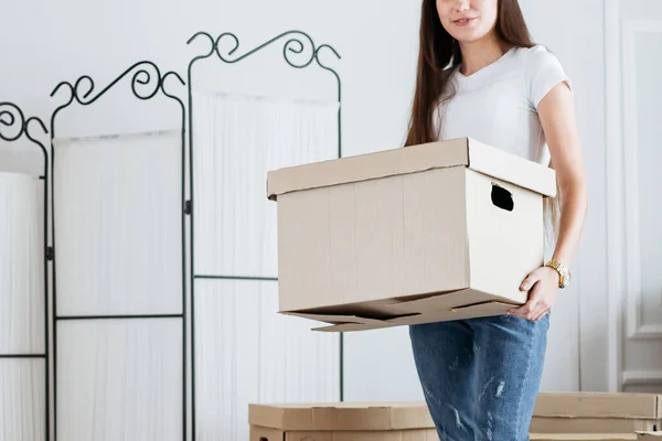 Mujer joven llevando cajas en su nuevo apartamento — Foto de Stock