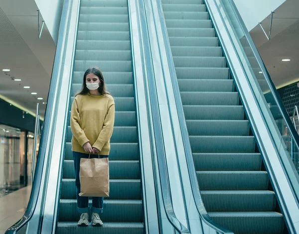 Junge Frau mit Schutzmaske bewegt sich in Einkaufszentrum — Stockfoto