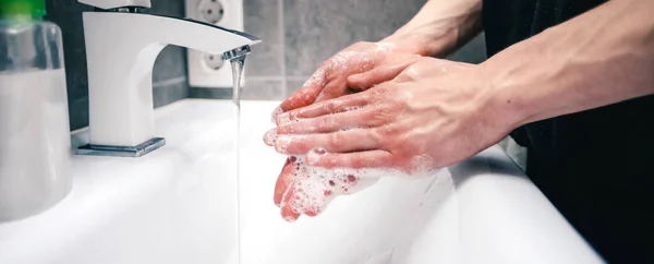 Close up. soap suds on the hands of a young man . — Stock Photo, Image