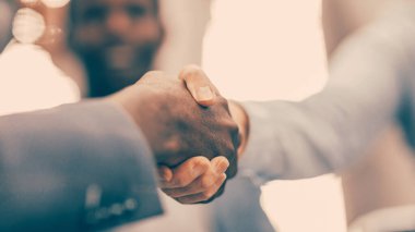 Kapat. İş adamlarının el sıkışırken bulanık görüntüsü.