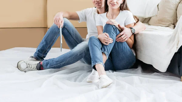 Casal feliz sentado no chão em um novo apartamento — Fotografia de Stock