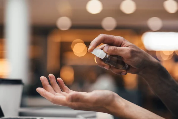 Nahaufnahme. Mann benutzt antiseptisches Handspray. — Stockfoto