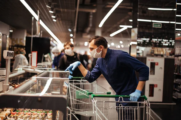 Client en gants de protection choisir des produits dans un supermarché. — Photo