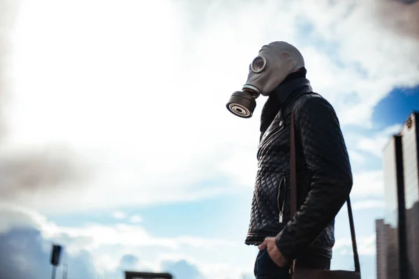 Casual jongeman in een gasmasker staan op straat in een lege stad — Stockfoto