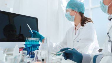 Laboratuvardaki bir bilgisayar ekranına bakan bir grup bilim adamı.