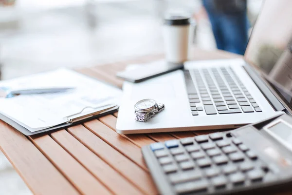 De cerca. imagen de una computadora portátil y calculadora en una mesa en un café. — Foto de Stock