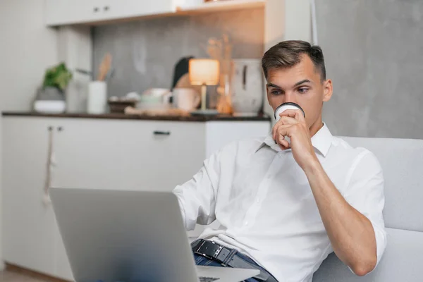 Ung man avkopplande sitter på soffan . — Stockfoto