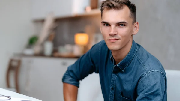 Young man sitting in a home chair. — Stock Photo, Image